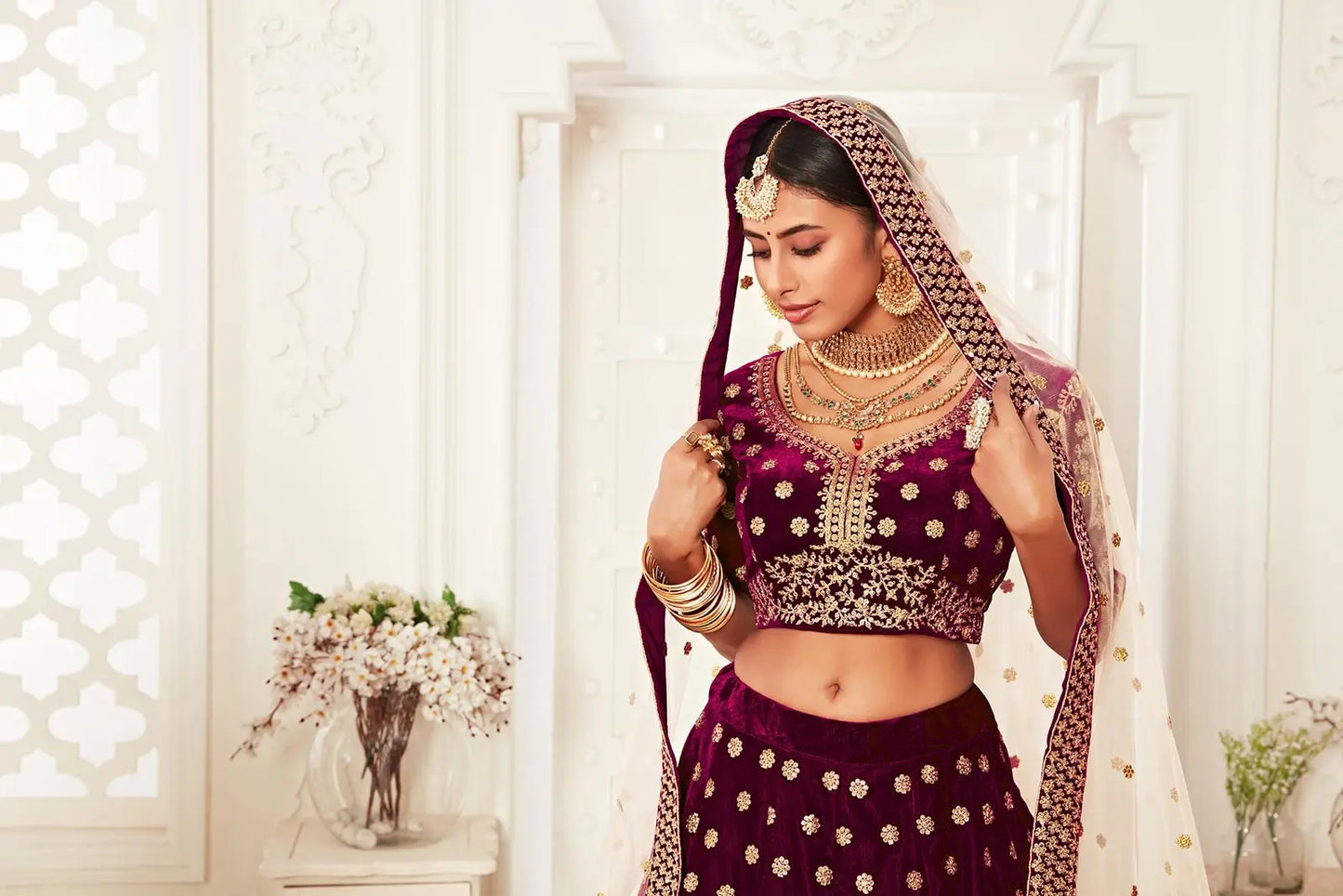 Lehenga en velours rouge sombre avec broderies en fil, zari et sequins.