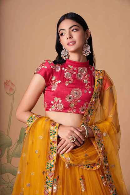 Lehenga jaune et rose fushia en tulle doux avec broderies en fil, zari, dori, sequins et incrustations de miroirs (travail de miroirs)