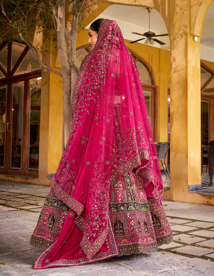 Lehenga de mariée rose fuchsia foncé avec détails multicolores traditionnel en velours premium inspiration de créateur COLLECTION SAHIBA